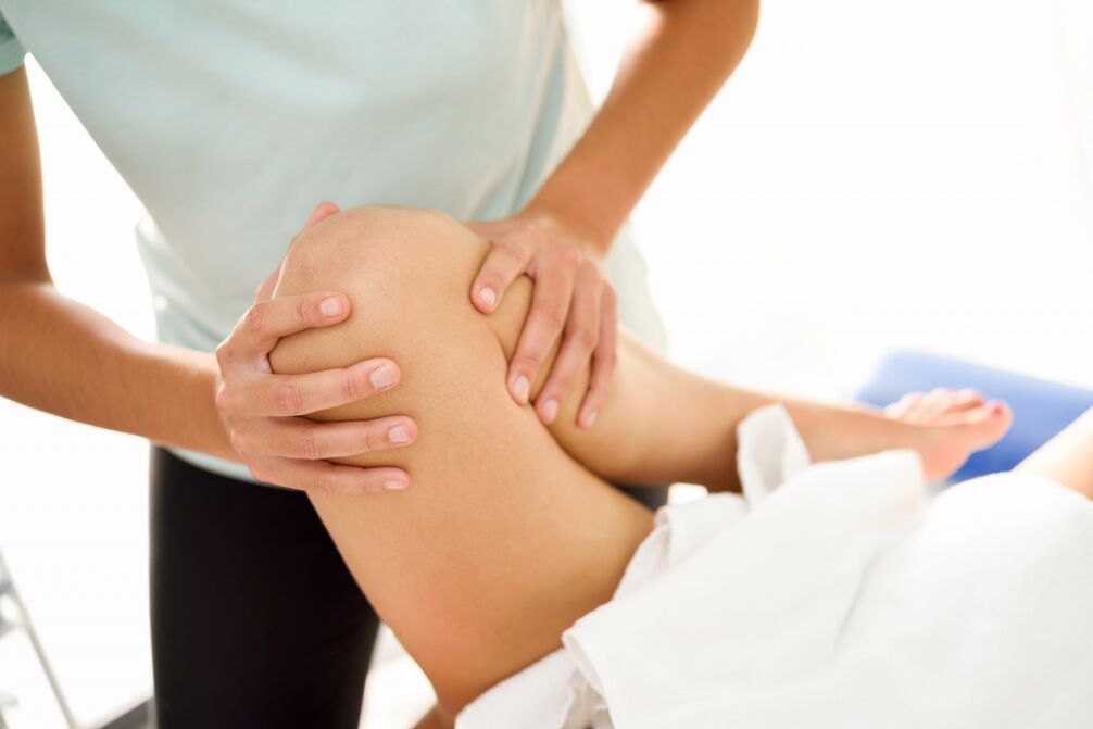 Specialista dělá terapeutickou masáž s artrózou kolena